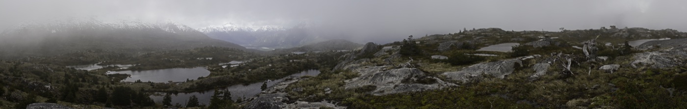 A misty Patagonian highland of tarns and weathered rock under low cloud