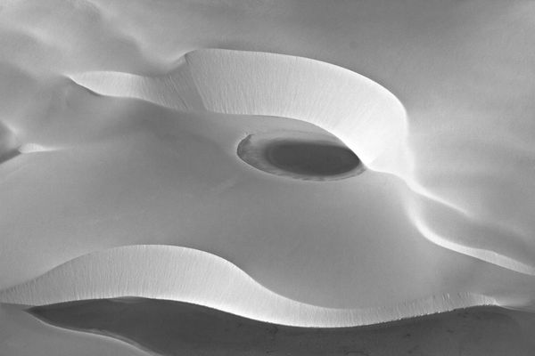 Aerial black-and-white abstract of the white sand dunes and dark lagoons of Lençóis Maranhenses, Brazil